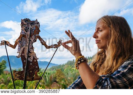 Woman Holds In Hand Old Traditional Shadow Puppet Of Bali Island - Wayang Kulit. Culture, Religion, 