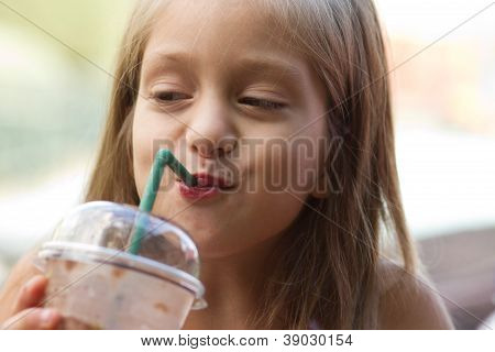 Rolig liten flicka drycker Milkshake