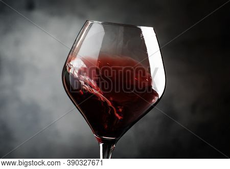 Spanish Dry Red Wine, Splash In Glass, From The Tempranillo Grape, Gray Stone Background, Defocused 