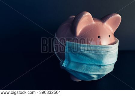 Global economy during coronavirus pandemic. Piggy bank wearing surgical face mask. Financial crisis, banking concept.