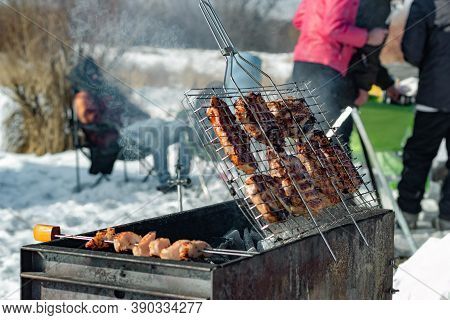 Winter Barbecue Outdoors, Grill Steak And Fork With Meat Over Hot Coals In A Bbq At Campside Cookout