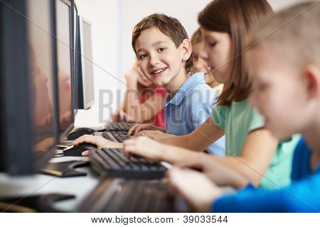 Fiksu poika katsot kamera computer-lesson muotokuva