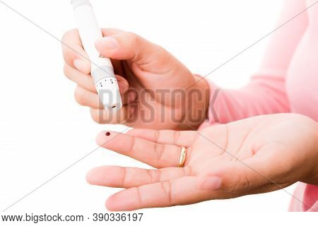 Closeup Woman Measuring Glucose Level Using A Hand Test Lancelet On The Finger She Monitors High Blo