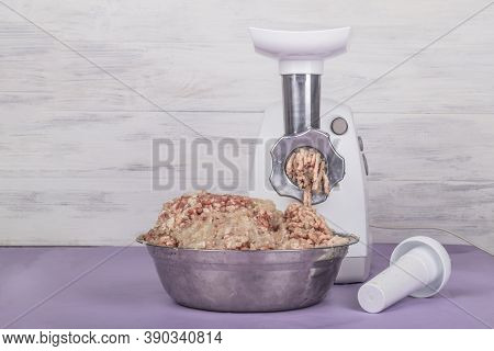Electric White Meat Grinder. Minced Meat Is Wound And Lies In A Metal Bowl. Copy Space. Text.