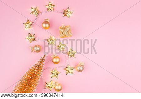 Golden Christmas Decorations With Christmas Tree, Glowing Stars Garland On Soft Light Pink Backgroun
