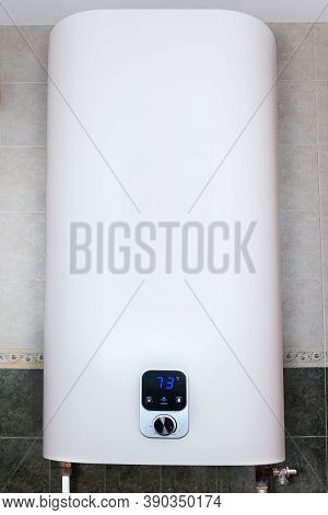 Household Electric Tank-type Water Heater, So Called Storage Water Heater Hanging On The Tiled Wall 