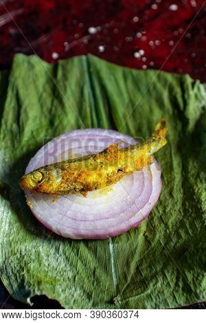 Closeup Of Cooked Mourala Fish Or Indian Carplet Fish On Onion Slice In Vertical Orientation