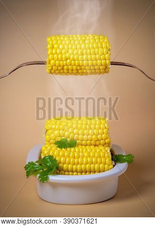 Vertical Arrangement Of Hot Steamy Succulent Corn On The Cob With Mealted Butter On A Plain Backgrou
