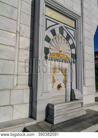 Turkey, Ankara - October 23, 2019: Gilded faucet in the white marble wall of the Melike Hatun Mosque in Ankara, outdoor. Delightful rich decor of the facade of a Turkish Muslim temple