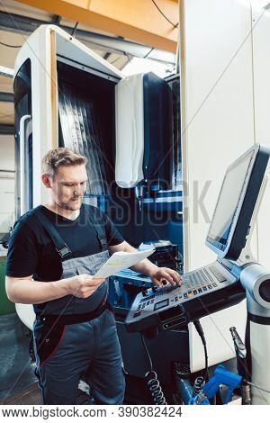 Competent Worker in industrial workshop programming a cnc machine