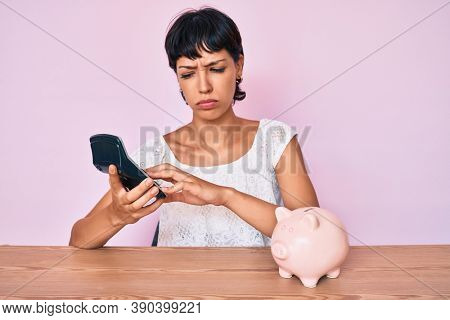Beautiful brunettte woman caculating money savings skeptic and nervous, frowning upset because of problem. negative person. 