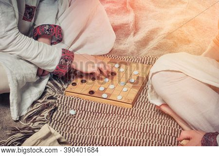 Tafl Is A Scandinavian Boardgame. Players At The Board Game A Retro Style. Two Men Playing Hnefatafl