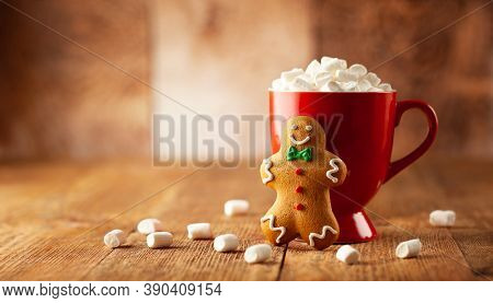 Christmas homemade gingerbread cookie and cup of hot chocolate with marshmallow on wooden table. Christmas food and drink concept