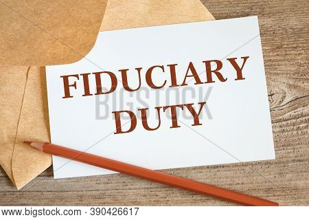 Open Craft Envelope And Card With The Words Fiduciary Duty, Pencil On A Wooden Surface.