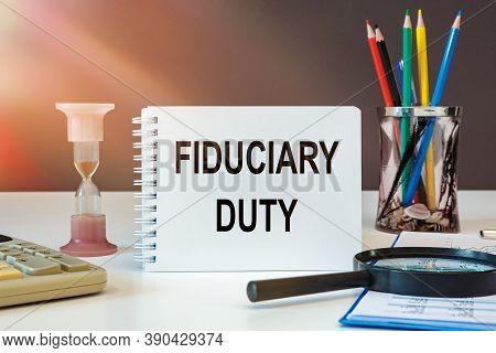 Desktop With Documents, Calculator And Notebook. On A Blockboard Inscription Fiduciary Duty