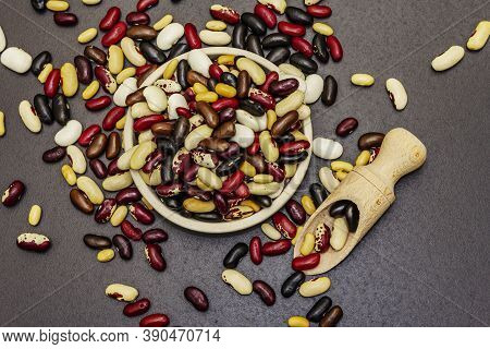 Mix Of Various Dry Legumes In Ceramic Bowl, Scattered On Black Stone Background