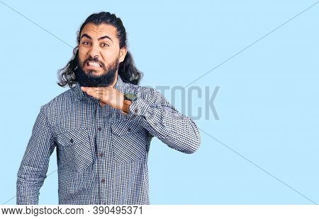 Young arab man wearing casual clothes cutting throat with hand as knife, threaten aggression with furious violence 