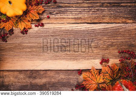 Autumn Leaves With Dogberry And Colorful Pumpkins Over A Textured Vintage Rustic Wooden Background W