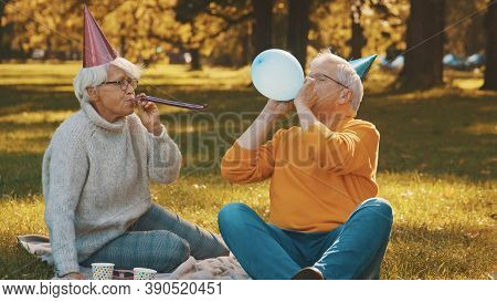 Elderly Couple Having Anniversary Picnik In The Park In Autumn. High Quality Photo