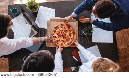 Happy Diverse Colleagues Spend Work Break Together Eating Takeaway Delivery Pizza In Office, Smiling