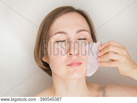 European Woman Applying Guasha Massage Close Up Portrait