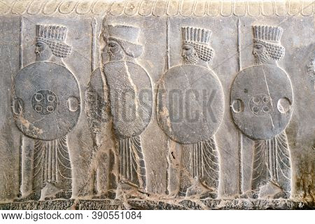 Ancient wall with bas-relief with assyrian warriors with with spears and shields, Persepolis, Iran. UNESCO world heritage site