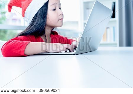 A 6 Year Old Asian Girl Wearing A Red Shirt Watching A Documentary From A Notebook With Determinatio