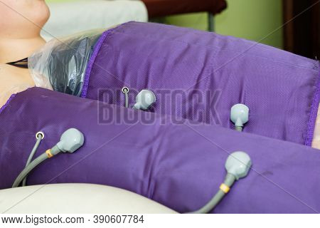 Young Beautiful Woman On Procedures In A Special Pressotherapy Suit In The Spa Salon. Treatment And 