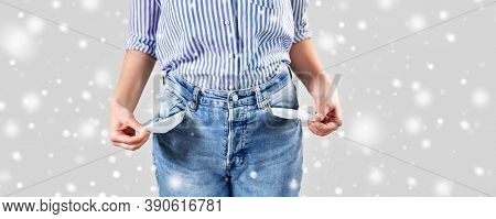 bankruptcy, financial crisis and poverty concept - close up of woman showing empty pockets in winter over snow on grey background