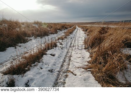 Tire Tracks In The Snow, Winter Road, Empty Road In Winter Goes Far To The Horizon, Covered With Sno