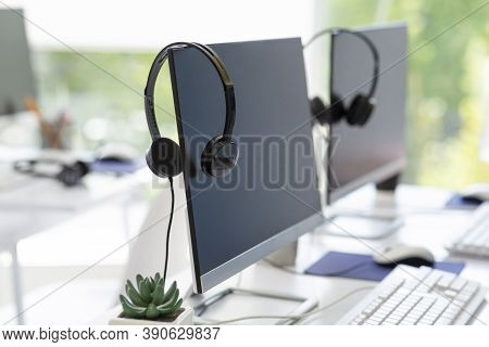 Computer Monitor With Empty Space For Your Design And Voip Headset On Desk At Modern Office. Contemp