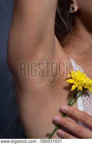 Young Girl With Hairy Armpits, Holding A Flower In Her Hand. Caring For The Vegetation Under The Arm