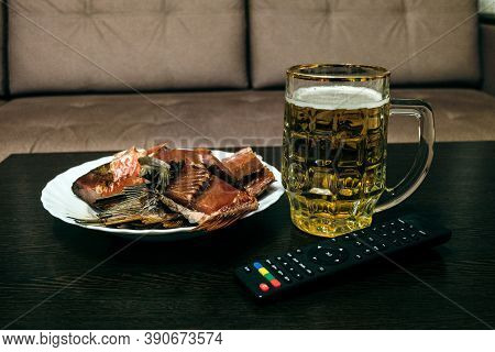 Glass Half-liter Mug Filled With Beer, Dried Smoked Fish And Tv Remote Control On The Table. Glass W