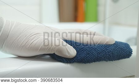 Nurse's Hand Cleaning The Bathtub Surface With A Dry Towel