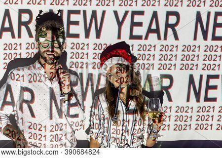 Beautiful Young Couple In Love Having Fun At New Year's Eve Party, Dancing And Blowing Party Whistle