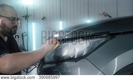 Car Detailing. Polisher Applies Special Polishing Compound Or Paste Or Wax To Optics Of Car Headligh