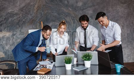 The Business Team Looks At The Laptop Screen. The Concept Of Waiting For The Result Of A Business Tr