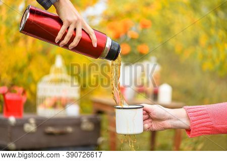 Cup Of Tea Or Coffee.  Strong Stream Of Hot Tea From A Thermos Into A Mug.  Fragments Of Two Girls' 