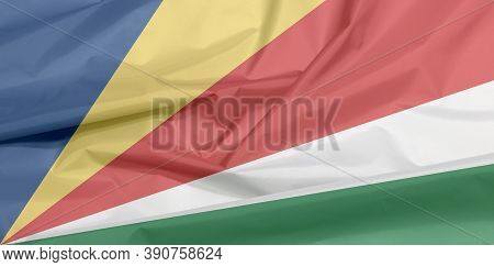 Fabric Flag Of Seychelles. Crease Of Seychelles Flag Background, Five Oblique Bands Of Blue Yellow R