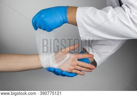 The Traumatologist Applies A Bandage To The Patient's Wrist. The Concept Of Helping With Fractures A