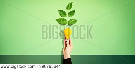 Person Holding A Light Bulbs With Green Leaves