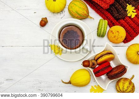 French Macarons In Autumn Colors With Cup Of Hot Tea