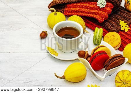 French Macarons In Autumn Colors With Cup Of Hot Tea