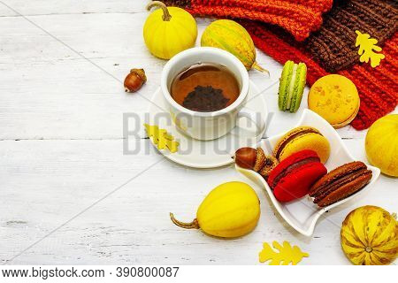 French Macarons In Autumn Colors With Cup Of Hot Tea