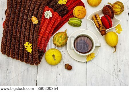 French Macarons In Autumn Colors With Cup Of Hot Tea