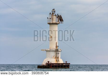 Metallic Lighthouse With Cormorant Birds On Top In Tsemes Bay Of Black Sea By Novorossiysk Town, Rus