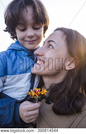 A Child Gives A Flower To His Mother, A Boy Walks With His Mom, A Woman Sniffs A Flower, A Portrait