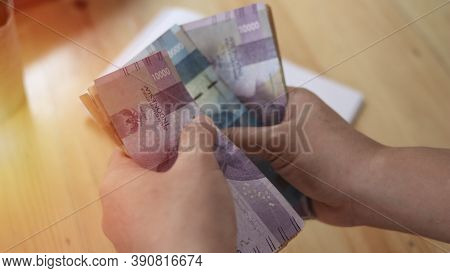 Close Up Of A Person Counting Money, Uang Indonesian Rupiah, Cash In Hand Concept