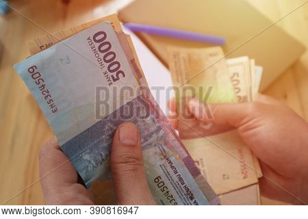 Close Up Of Woman Hand Counting Money Uang Indonesian Rupiah And Making Notes, Money Financial Manag