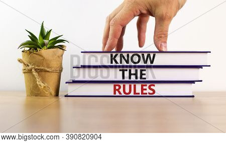 Books With Text 'know The Rules' On Beautiful Wooden Table. Male Hand And House Plant. White Backgro